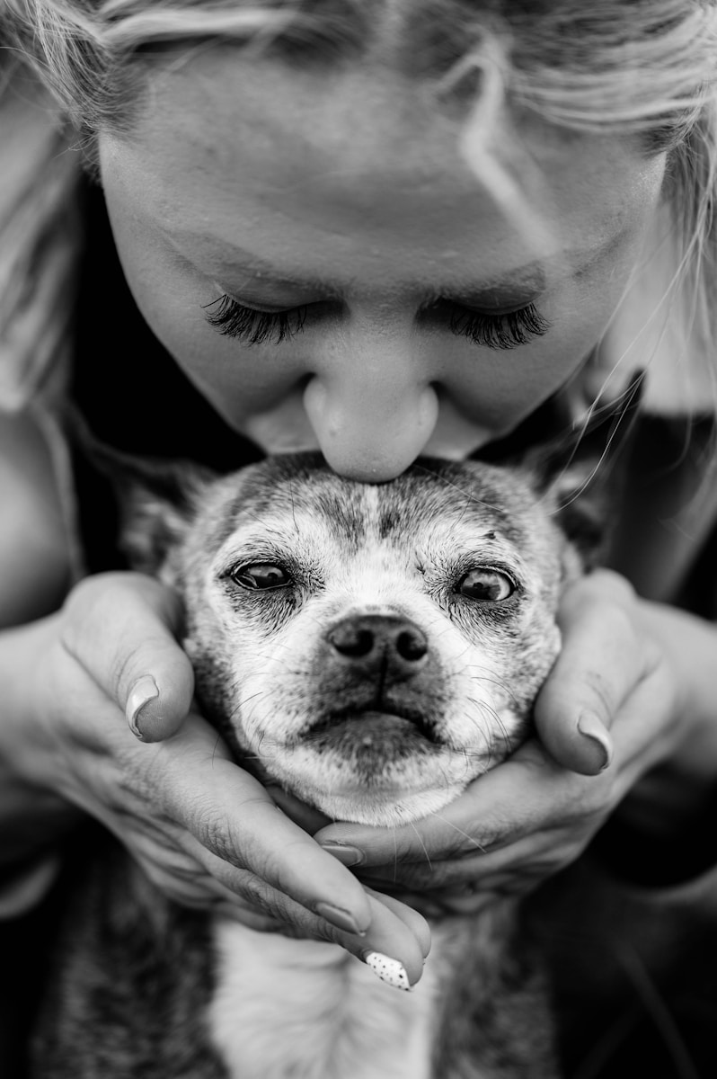 a woman holding an old dog with pet insurance in her hands